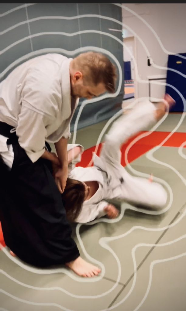 Två personer tränar aikido. Denna kastteknik heter kotegaeshi.